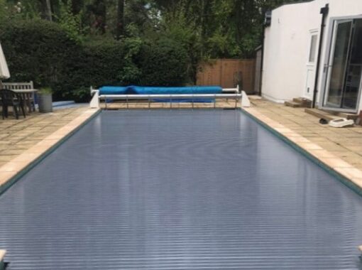 Grey slatted swimming pool cover on an outdoor swimming pool