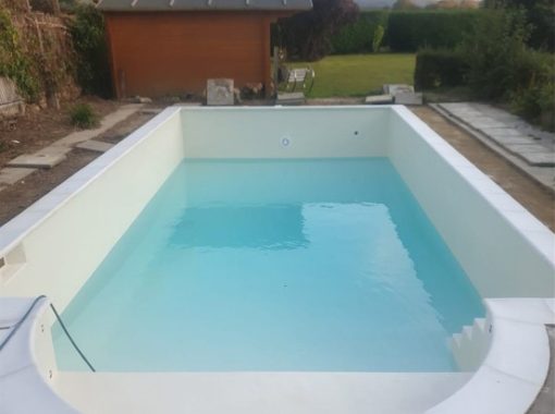 White fibreglass swimming pool half full with water