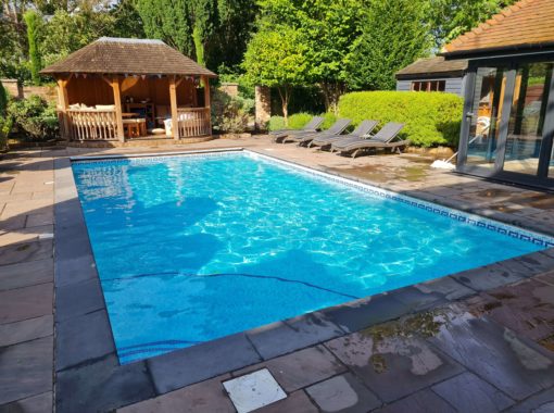 Outdoor swimming pool with sunbeds and an outbuilding