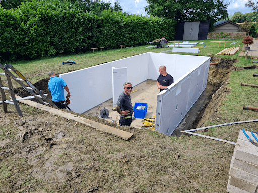 3 men installting HeatForm panels in a new swimming pool construction project