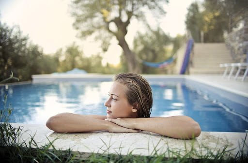 Woman relaxing at the edge of a swimming pool