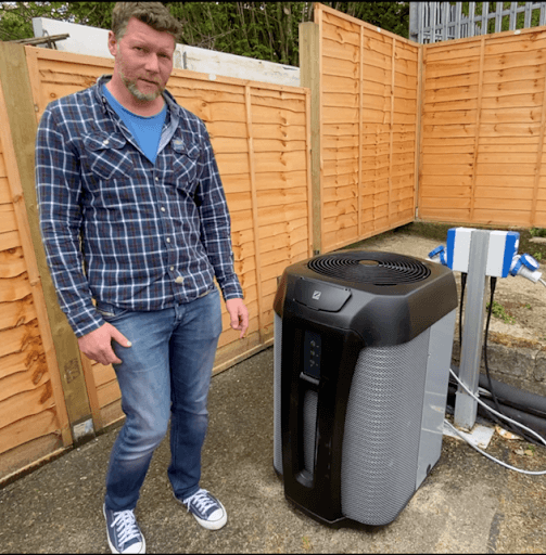 James phillpot standing next to a swimming pool heat pump