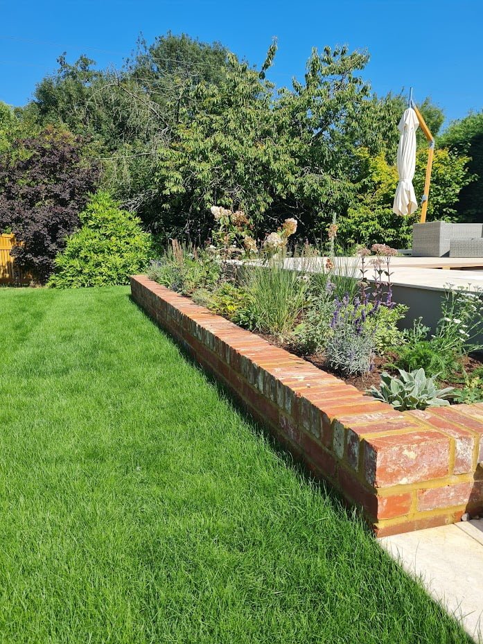 Flower beds and greenery surrounding an outdoor swimming pool