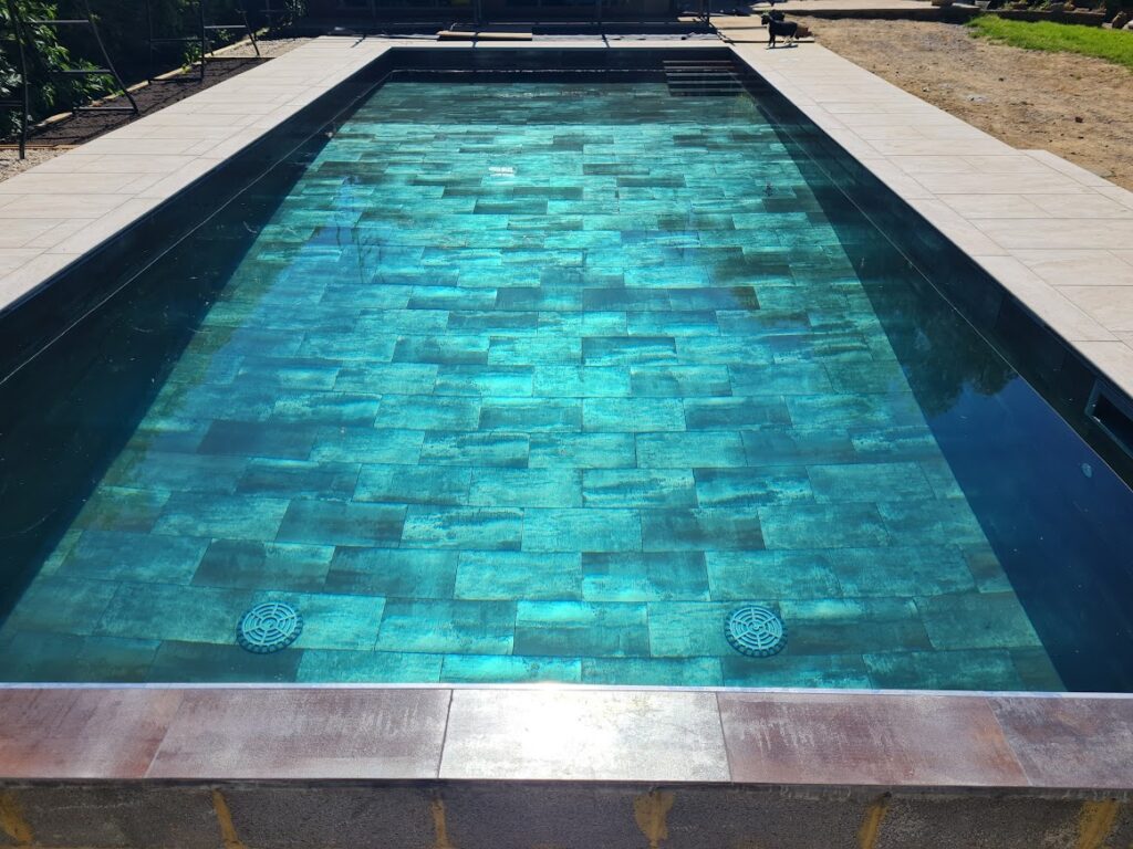 Rectangle swimming pool with copper tiles filled with water