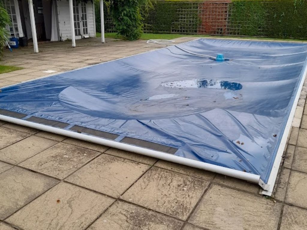 Blue winter debris pool cover on an outdoor swimming pool