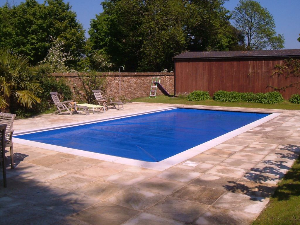 Blue swimming pool cover on an outdoor swimming pool in a back garden