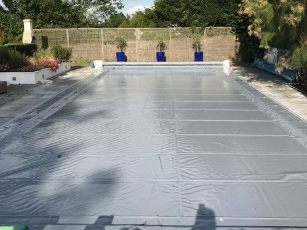 Grey pool safety cover on a swimming pool