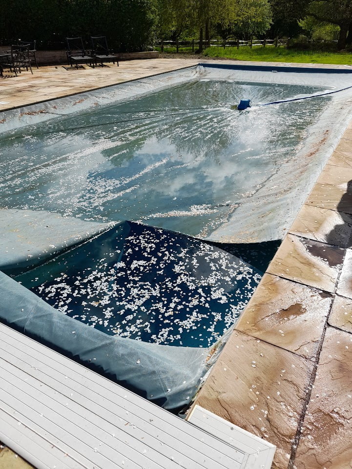 Ripped swimming pool cover exposing the water of the swimming pool