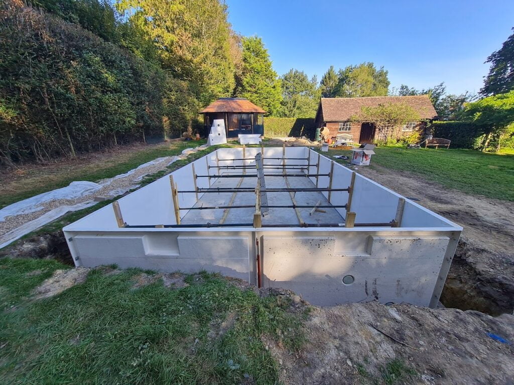 An outdoor swimming pool foundations being constructed out of heatform panels