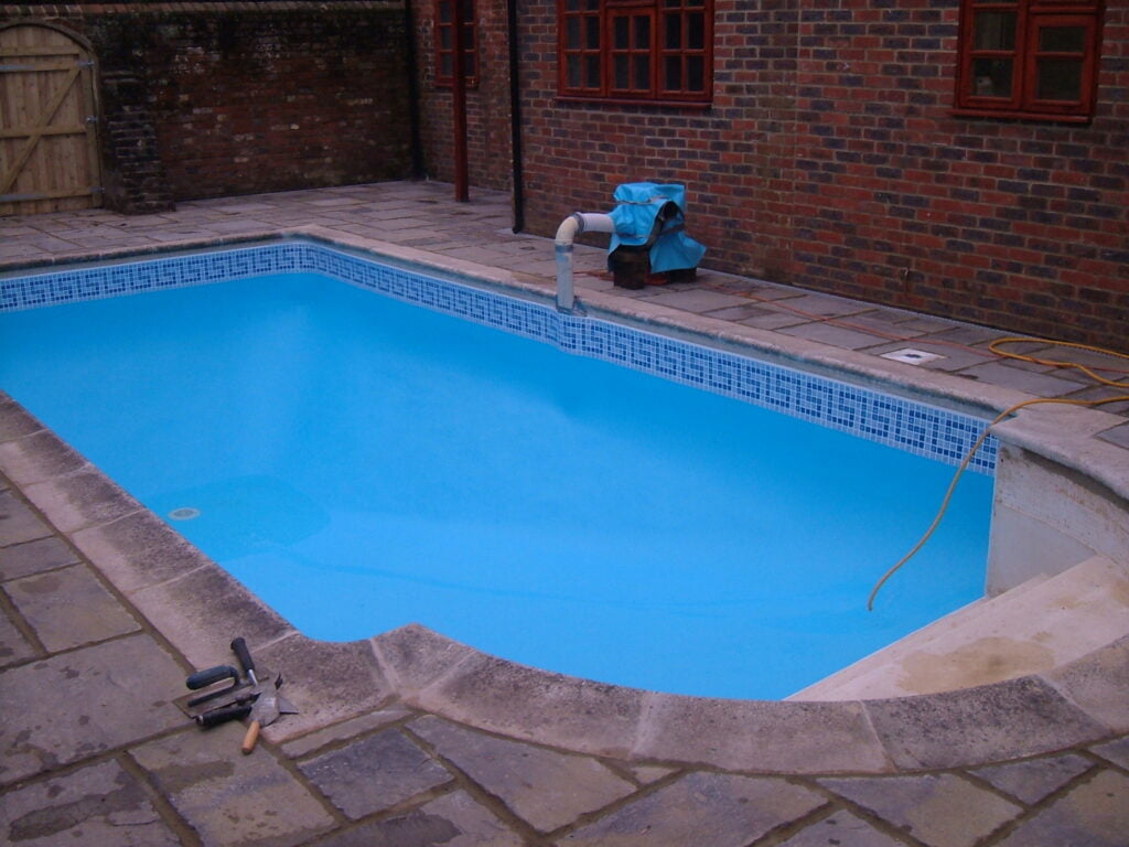 Outdoor swimming pool having pool liner fitted
