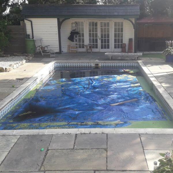 dirty swimming pool with tarpaulin inside