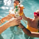 People holding drinks in a swimming pool