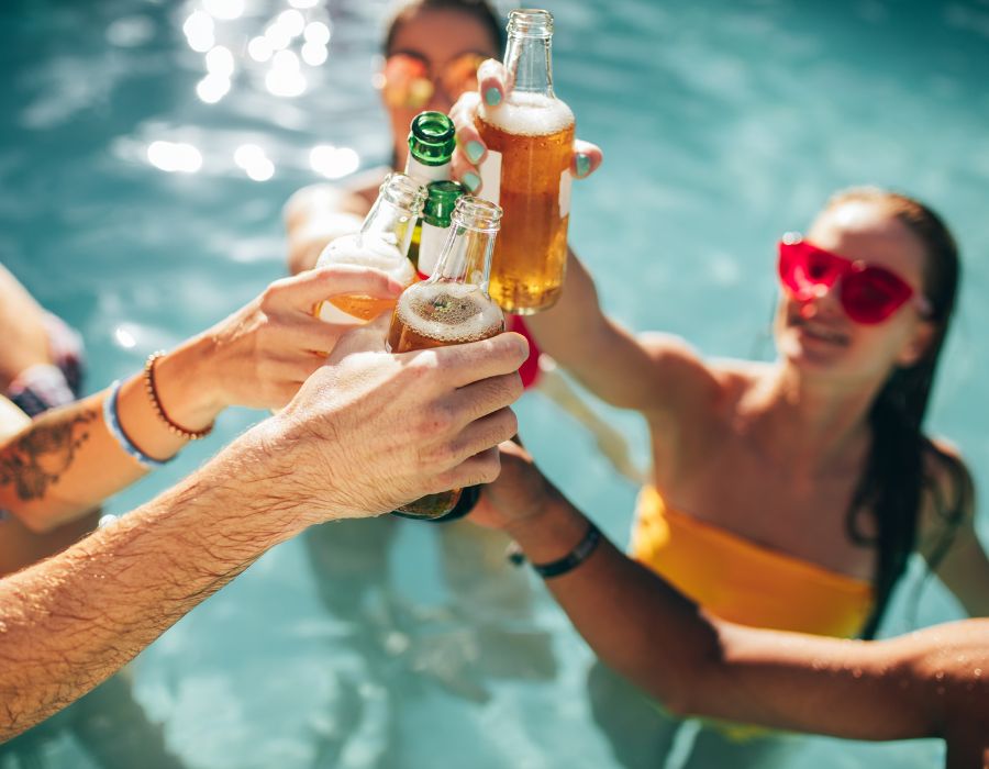 People holding drinks in a swimming pool