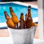 Beers in a cool bucket next to a pool