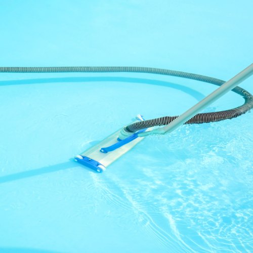 cleaning the bottom of a pool with an underwater vacuum brush