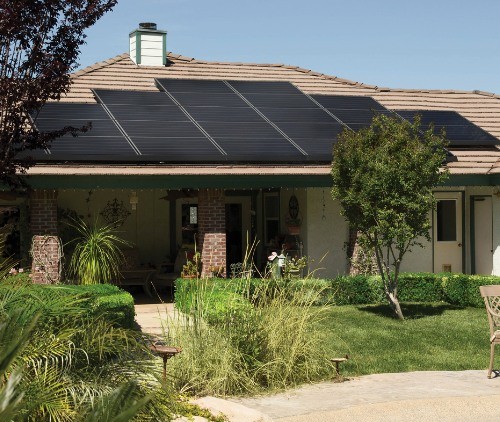 solar panels on a roof of a house with a pool