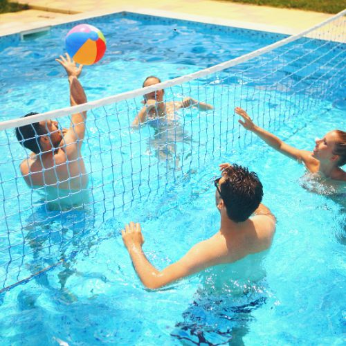people playing volleyball in a swimming pool
