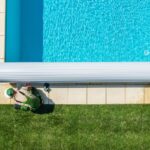 pool maintenance man working on pool cover