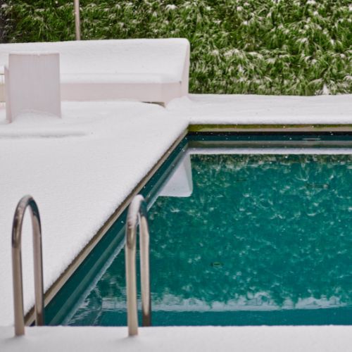outdoor swimming pool surrounded by snow