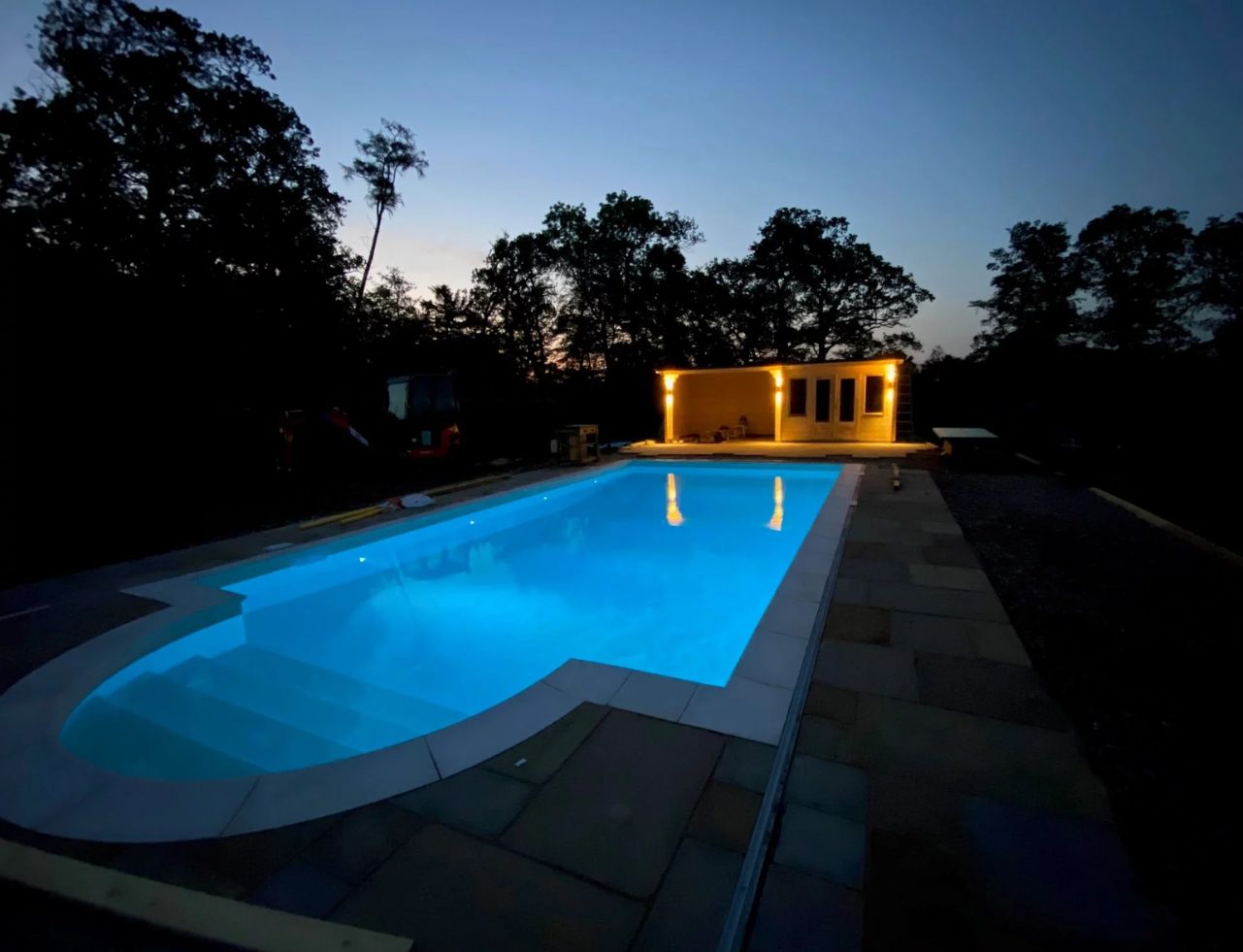 completed pool refurbishment with lights in the evening